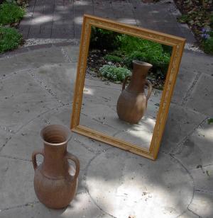 Marco ornamentado de un espejo antiguo reflejando una habitación con atmósfera satírica